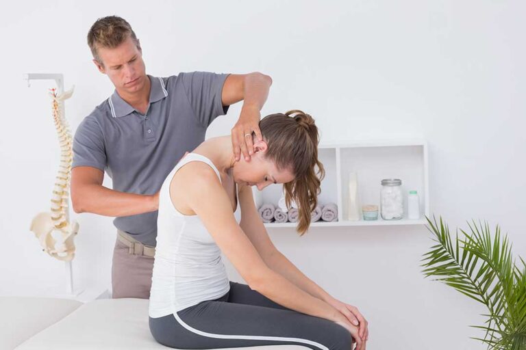 A chiropractor performing a gentle spinal adjustment on an adult patient in a well-lit clinic room.